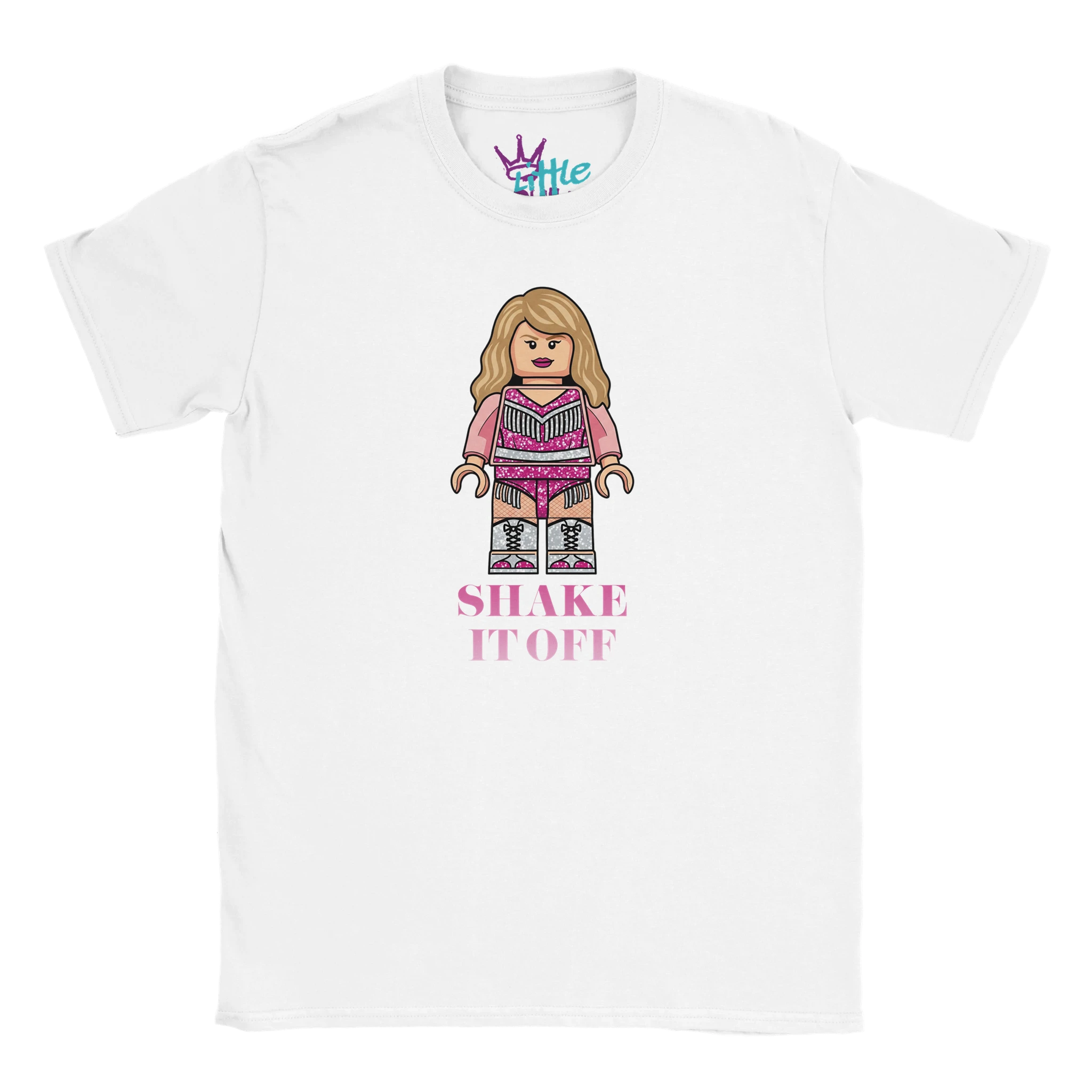 The Little Cult Brick Eras Icon x Blocks Kids T-Shirt features a LEGO-inspired icon with long blonde hair in a glittery pink outfit and "SHAKE IT OFF" text. Brand logo at inner collar. Perfect Swiftie merch for kids!.